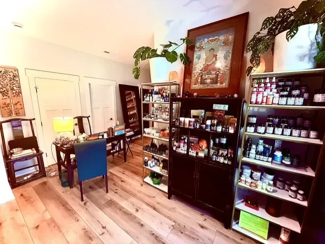 Clinic Entrance, with a small desk and sheves ofhealing herbs and supplements
